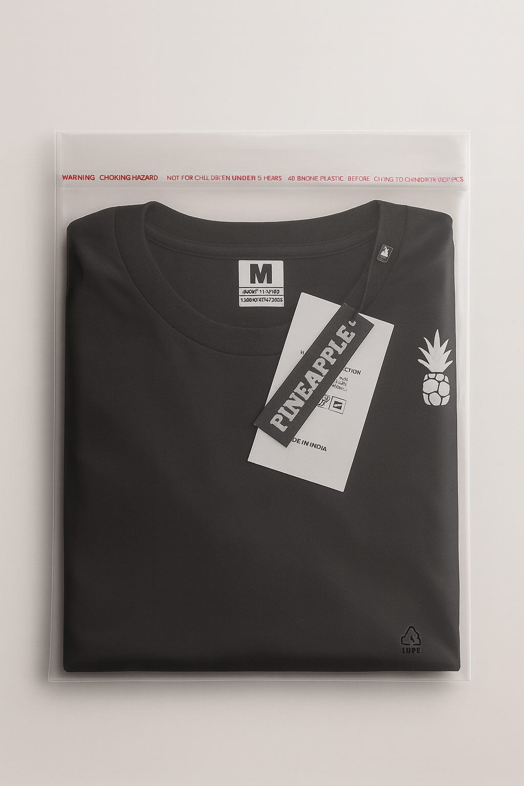 Black t-shirt with a tag labeled in a clear package on a light gray background