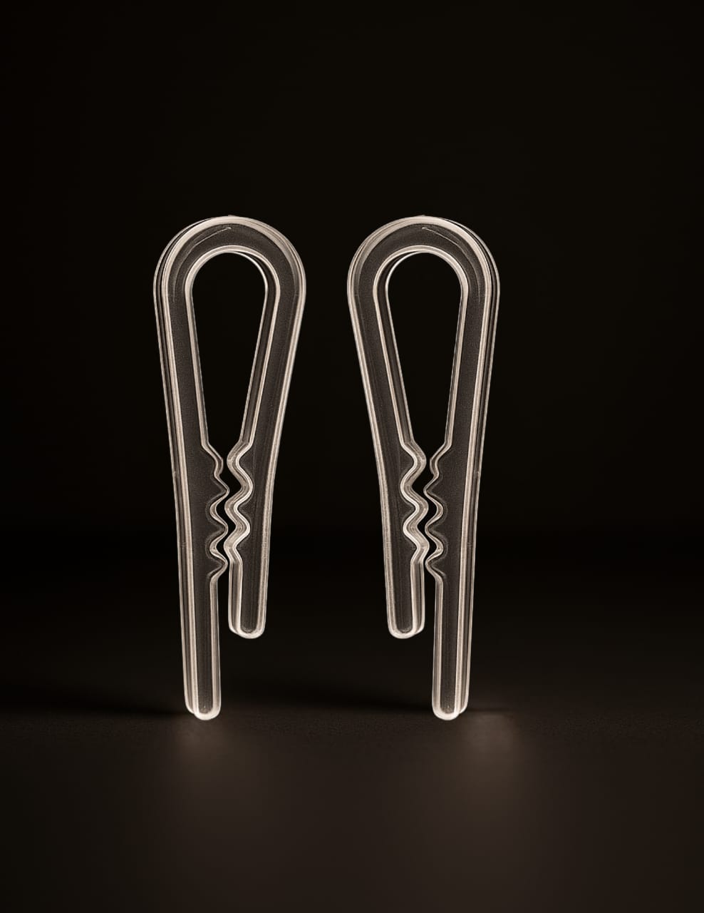 transparent pride pani clip pair with zigzag grip edges on dark background
